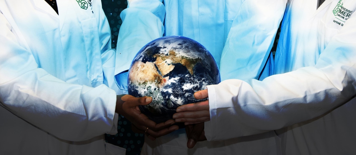 three scientists holding a globe