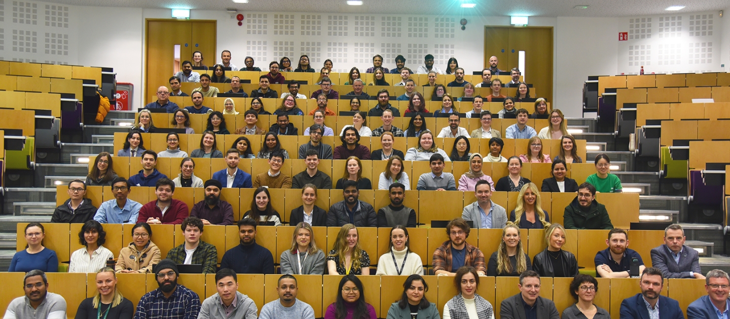 Group of researchers and staff at Bernal smiling in the lecture theatre