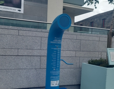 An image of the Poetry Jukebox in Galway. It is a blue pipe with a handle and a speaker on top