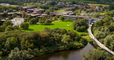 Aerial view of U.L. campus on sunny day, featuring the Living bridge and plassey house