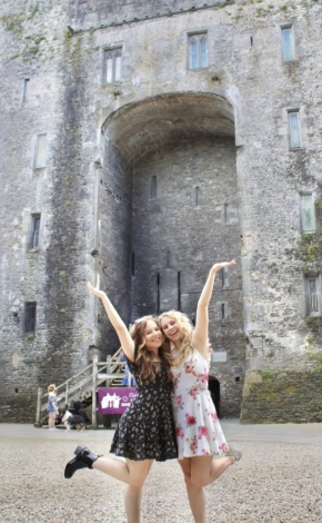 girls standing in front of a castle