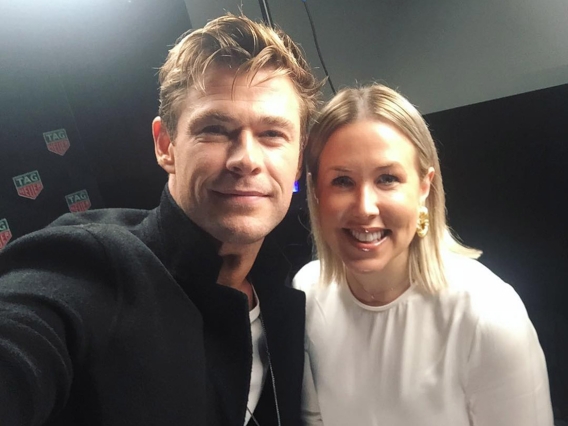 Actor Chris Hemsworth taking a selfie with a blonde woman in a white top