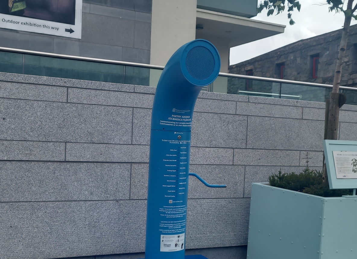 An image of the Poetry Jukebox in Galway. It is a blue pipe with a handle and a speaker on top