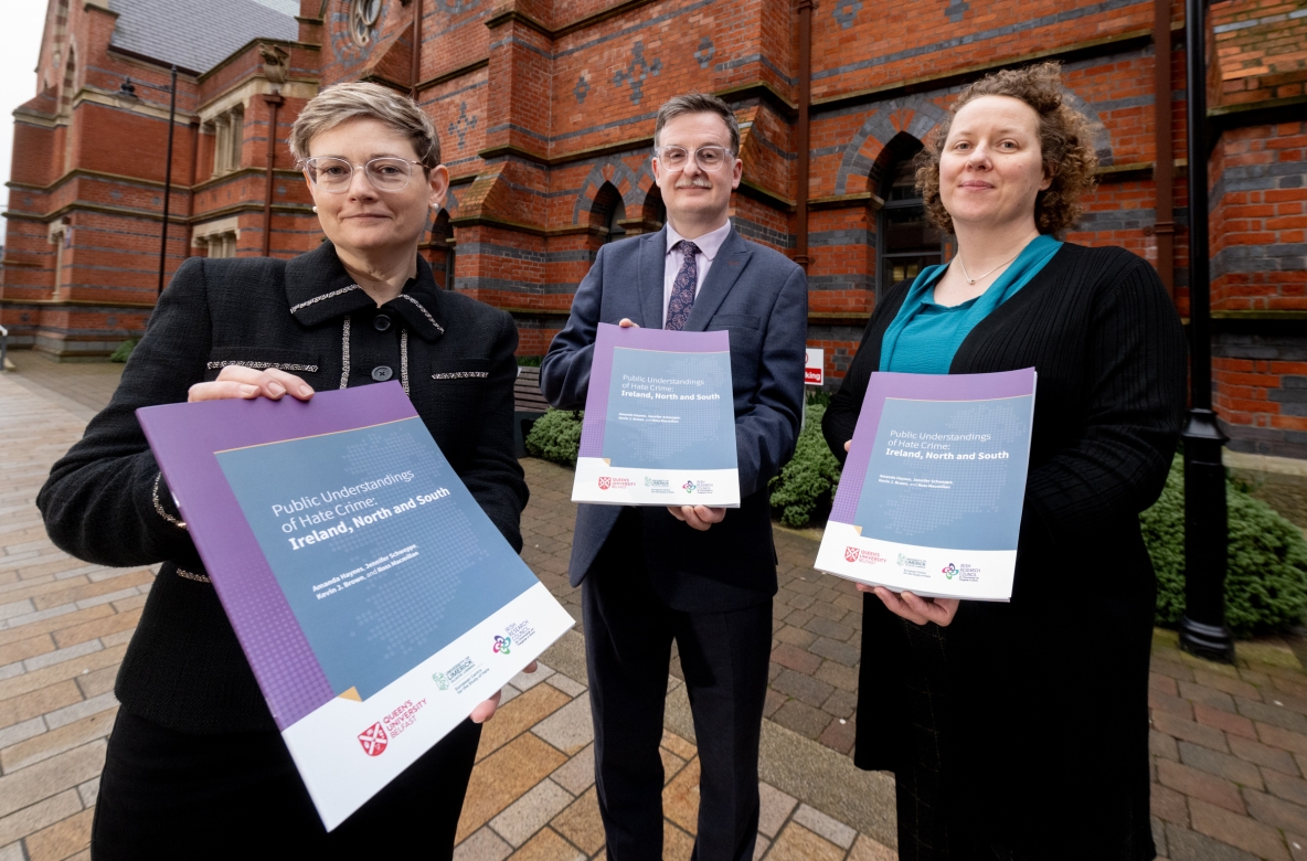 A picture of three academics holding copies of their research