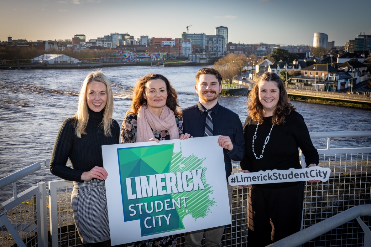 Alli McNamara and Global staff from other Limerick colleges holding Limerick Student City signs in front of the River Shannon