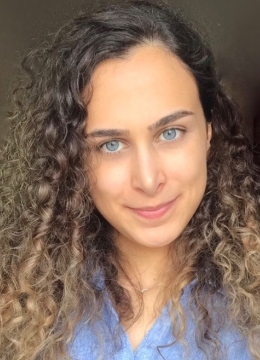 A woman with blue eyes and curly light brown hair
