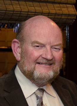 A man with a beard wearing a suit smiling