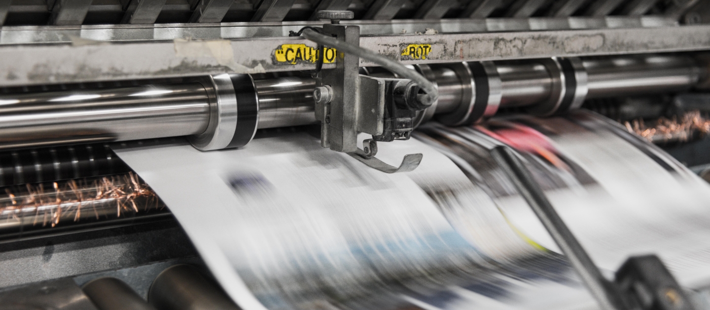 close up, high-speed shot of newspapers being printed 