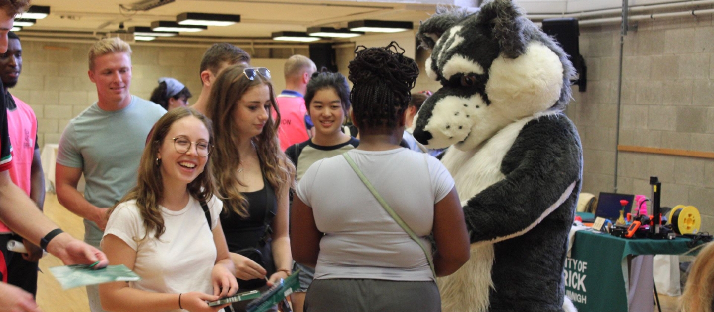 Photo of Wolfie with students at the Student Support fair for Orientation 2023