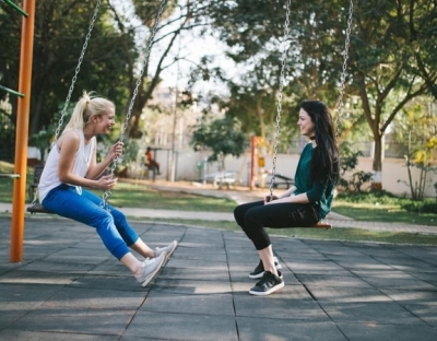 Image shows two students on swings 