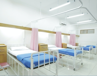 Image shows hospital beds lined in a row 