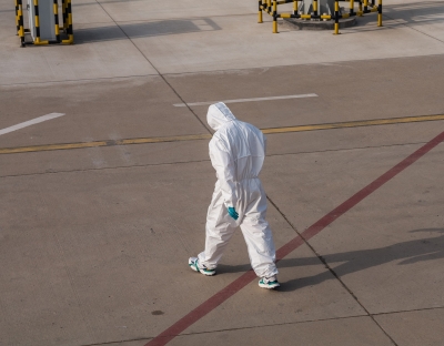 Person walks wearing hazmat suit