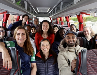 Group of students and staff on the bus on the way to this event looking towards the camera smiling. 