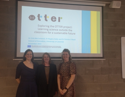 Dr. Orla McCormack, Dr. Elaine Kinsella and Dr. Deirdre O Neill standing in front of a presentation of the OTTER Project