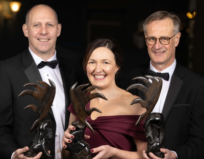 A picture of three alumni award winners with their trophies