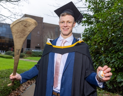Tipperary hurler Bryan O’Mara who graduated from UL’s Kemmy Business School, pictured in his robes and holding a hurley and sliotar