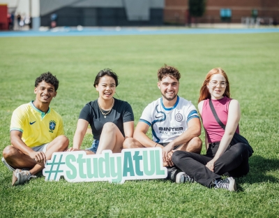 Students holding a #StudyatUL sign before the Speed friending event in September 23 orientation