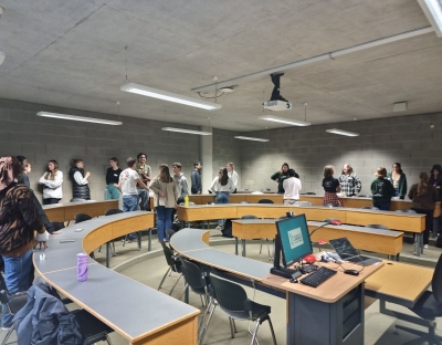 Pairs of students around a room engaging in a speed-friending exercise.