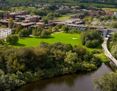 Aerial view of U.L. campus on sunny day, featuring the Living bridge and plassey house