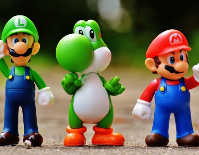 A focus photo of plastic figurines representing Luigi, Yoshi and Mario from Nintendo's Super Mario gaming franchise.