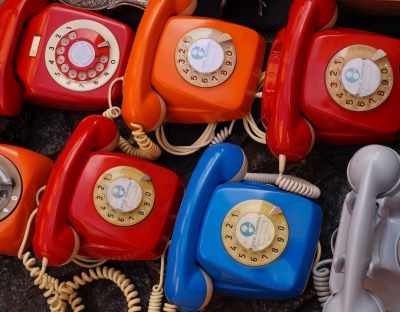 Photo of Seven Assorted Colored Rotary Telephones.