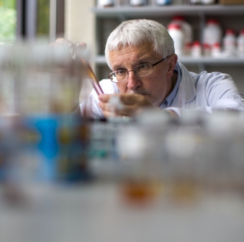 Dr Mike Zaworotko observing test tubes of various liquids