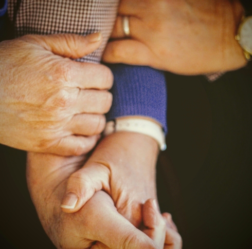 stock image of older persons holding hands