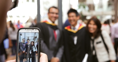 graduating student getting photo taken on smartphone