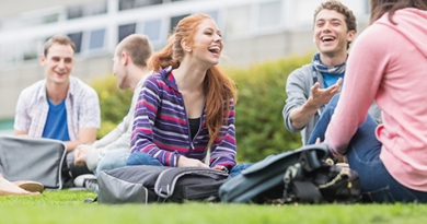 Students sitting on grass laughing