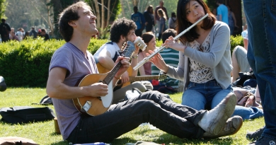 Students playing instruments on grass