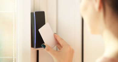 A woman holds a swipe card up to a door which has a card entry system