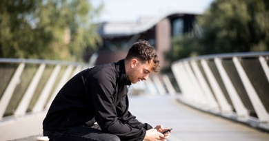man on his phone sitting on the living bridge