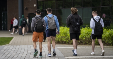Four student walking towards the library with their backs facing the camera