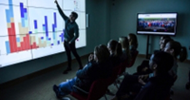 Image of Data Visualisation Room in UL library , person pointed at the screen in front of an audience