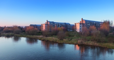 Image shows village on campus across the river