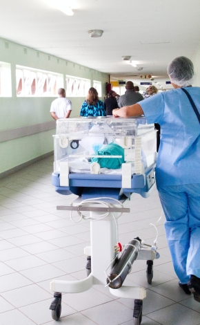 A nurse pushing a incubator through a hallway. Photo by Hush Naidoo Jade Photography on Unsplash