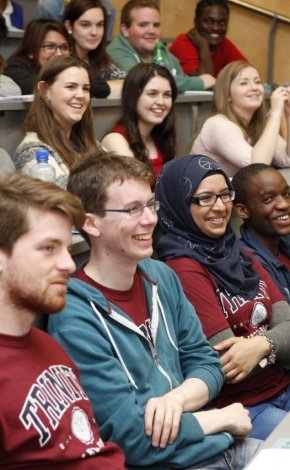 Group of students smiling and laughing in a lecture hall