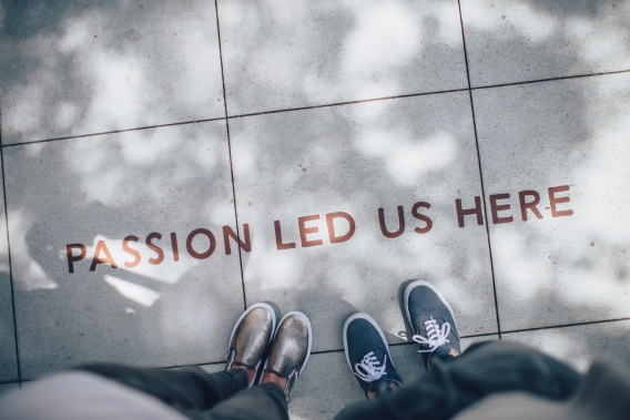 Image of two people standing by writing on the floor.Photo by Ian Schneider on Unsplash