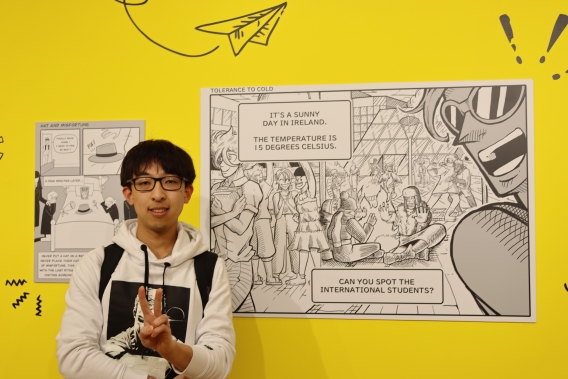 Illustrator Edison Cai in front of one of his artworks