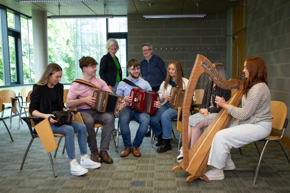 Group of students sitting in circle playing their instruments 