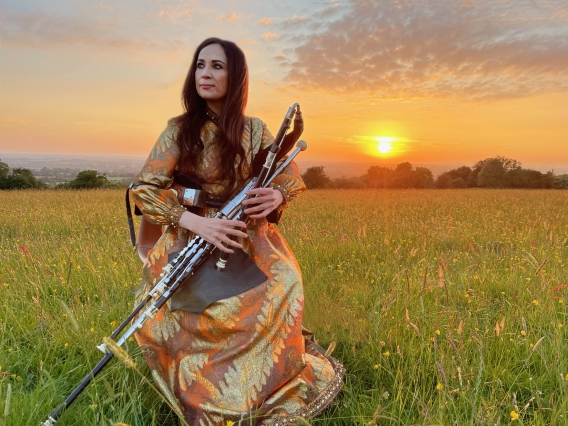 louise playing instrument in a field
