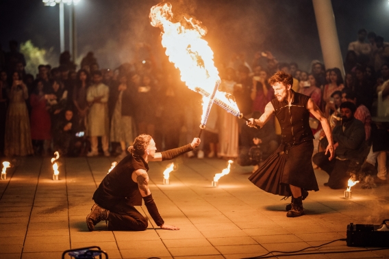 Burning Circus show their skills with a fire sword fight as Diwali 2023 guests watch in the background
