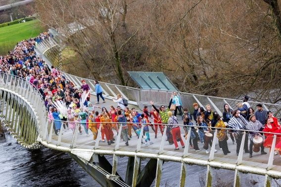 People walking across the Living Bridge in celebration, shown from above