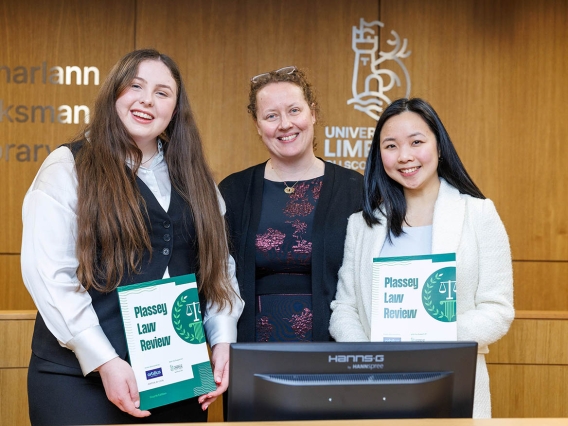 Three women smiling for a photo holding copies of the Plassey Law Review