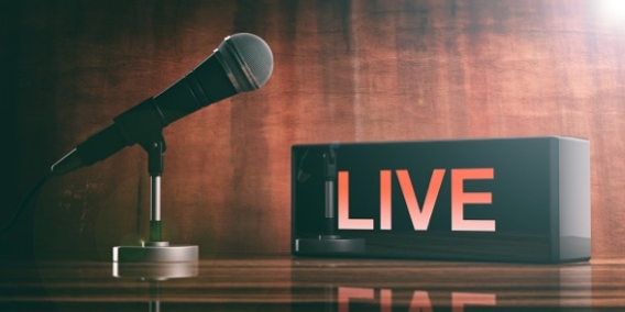 image of a microphone with announcement saying 'live' behind it.