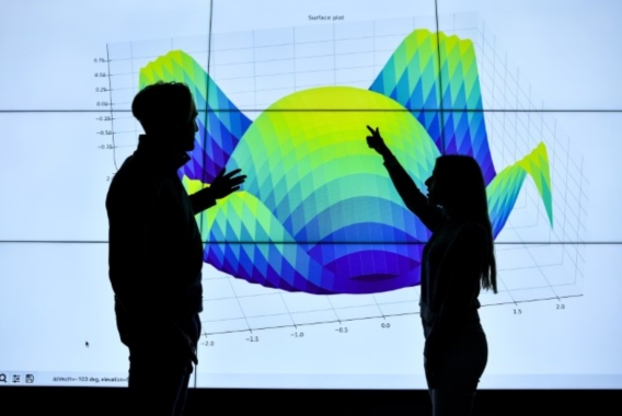 Two people standing in front of Data Visualisation