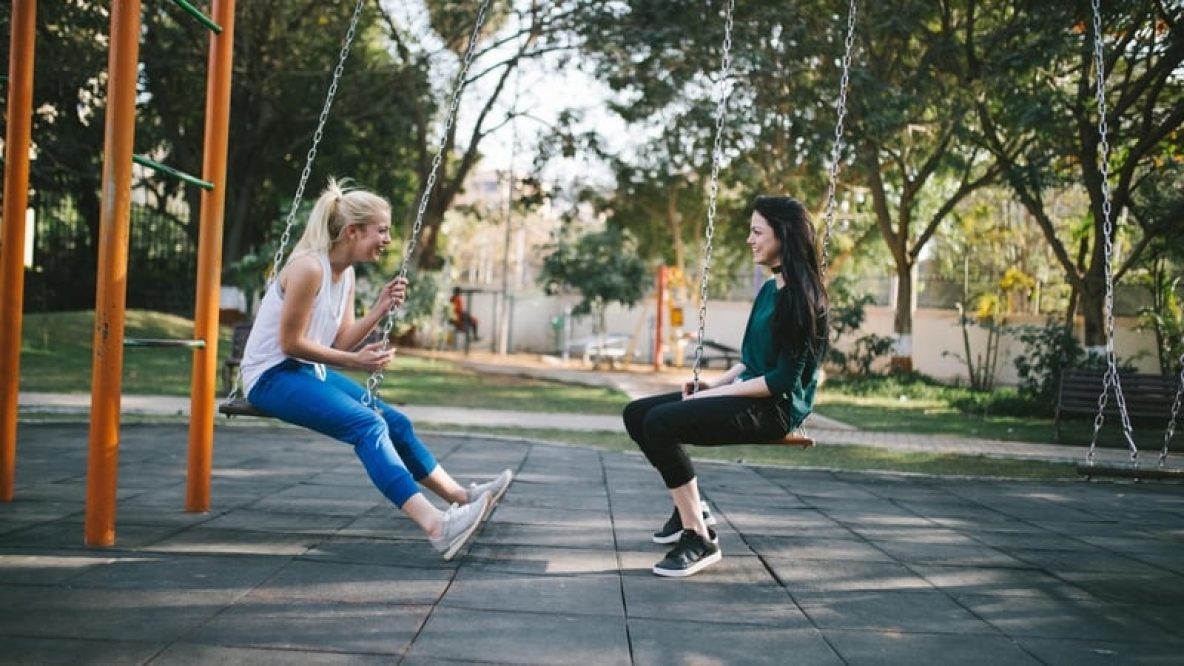 Image shows two students on swings 