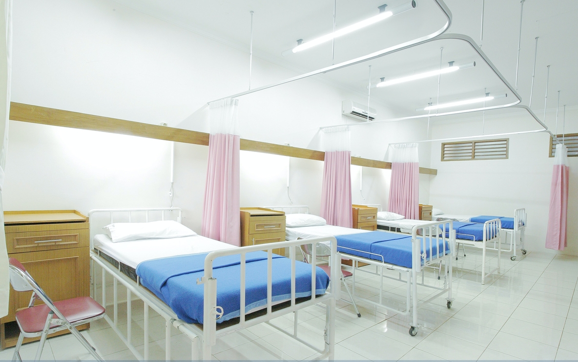 Image shows hospital beds lined in a row 