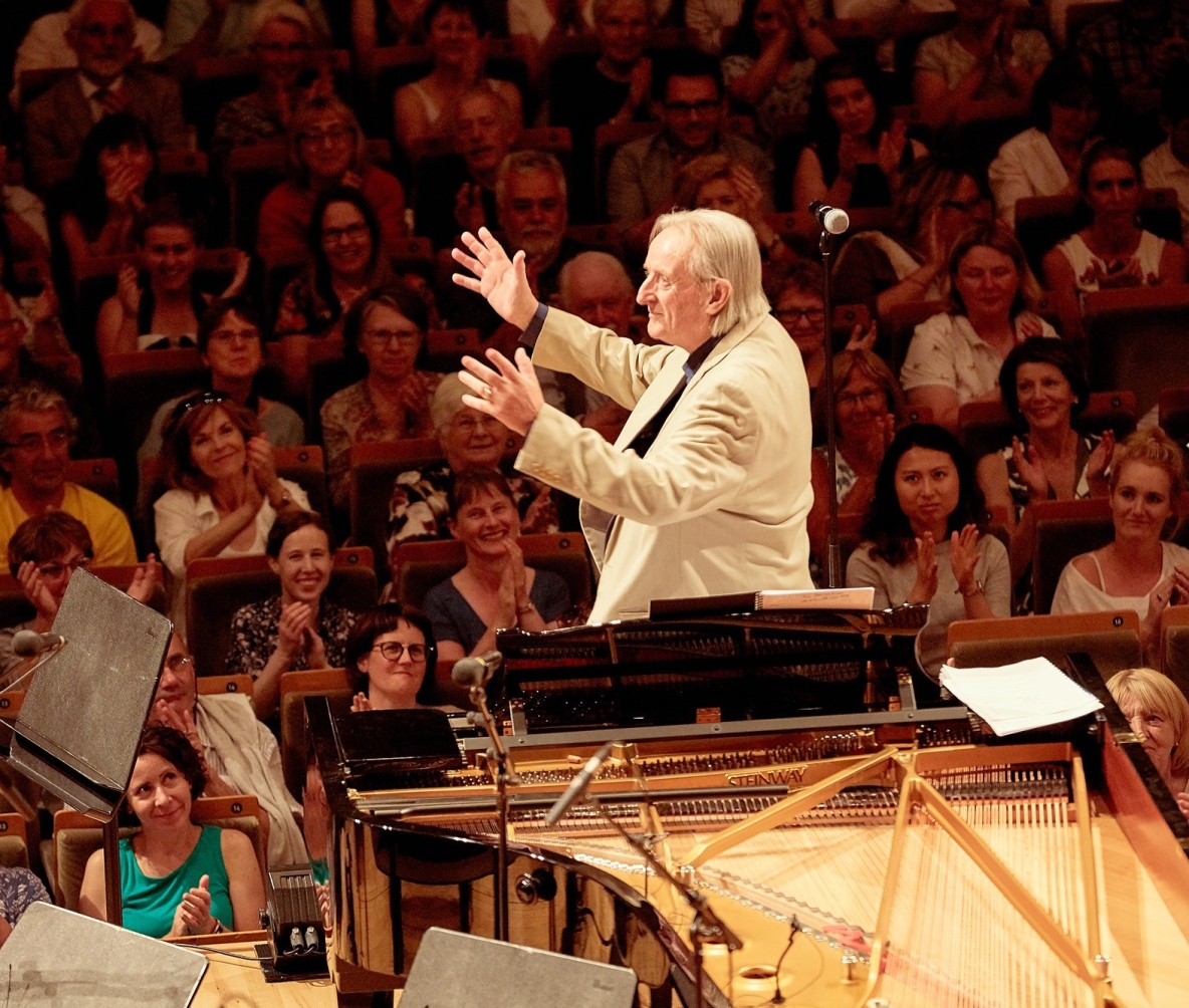 image shows conductor and an orchestra 