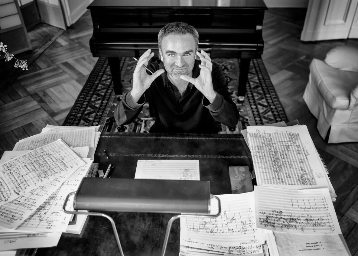 Jörg Widmann at desk surrounded by sheet music